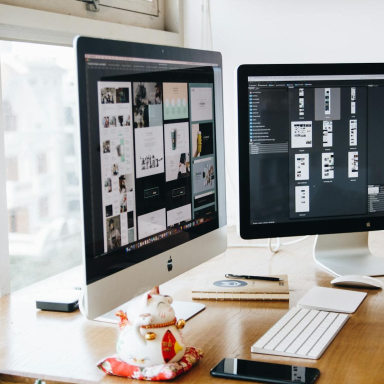 A sleek modern office setup featuring dual monitors, Apple devices, and creative decor in an indoor workspace.